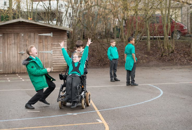 Disabled and non disabled boys playing in a playground