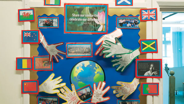 A classroom display with paper hands, paper globe and the words "share our similarities, celebrate our differences"