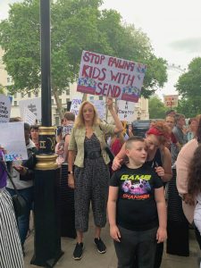 Woman holds placard saying "stop failing kids with SEND"