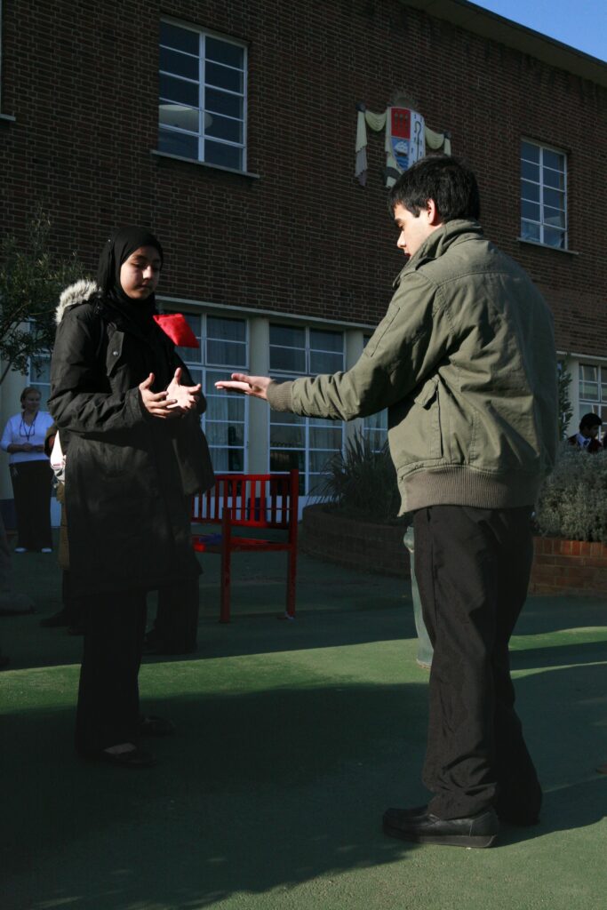Young people attending Monega Primary School in Newham, London. Wide angle shot showing colllaborative and group activities: Catching, Langdon