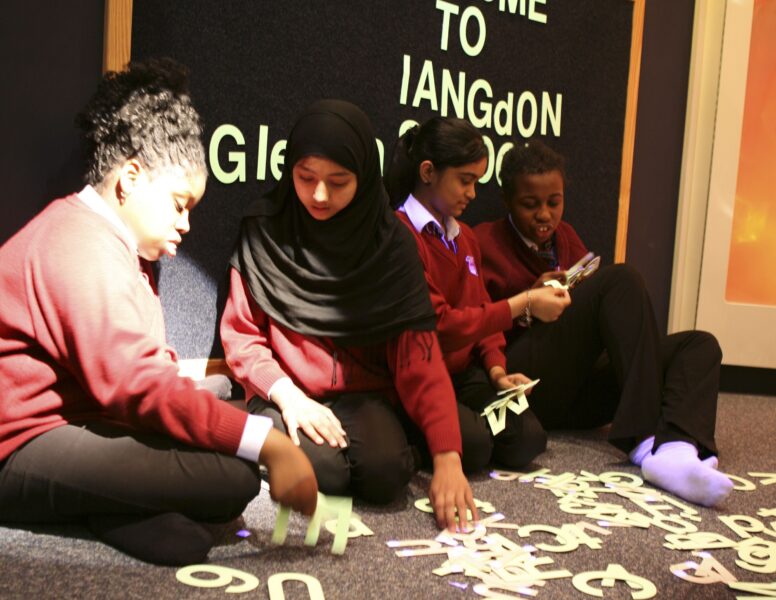 Young people attending Monega Primary School in Newham, London. Wide angle shot showing colllaborative and group activities: Peer work in soft play area, Langdon