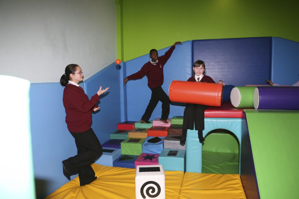 Young people attending Monega Primary School in Newham, London. Wide angle shot showing colllaborative and group activities: soft play