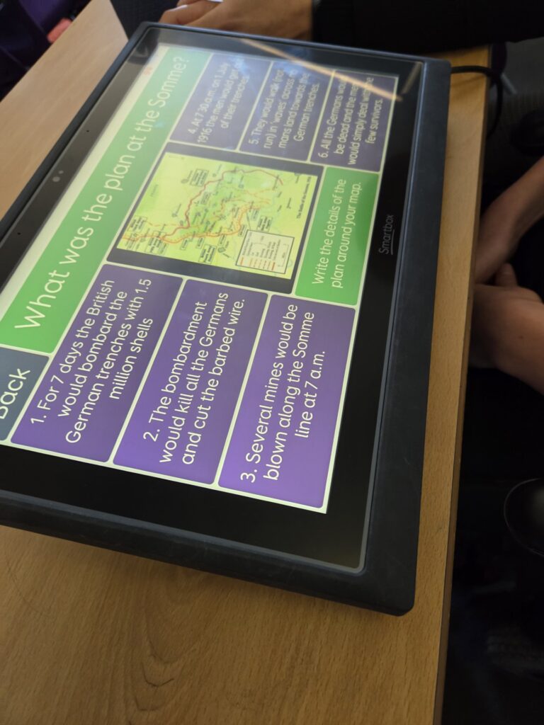 A screen on a desk showing a lesson resource about the Somme. The information is set in green and purple text boxes around a map.